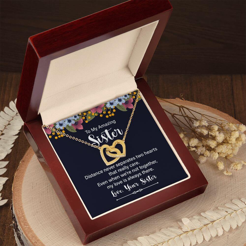Amazing Sister yellow gold interlocking hearts necklace in open mahogany luxury box on wood slice with dried flowers